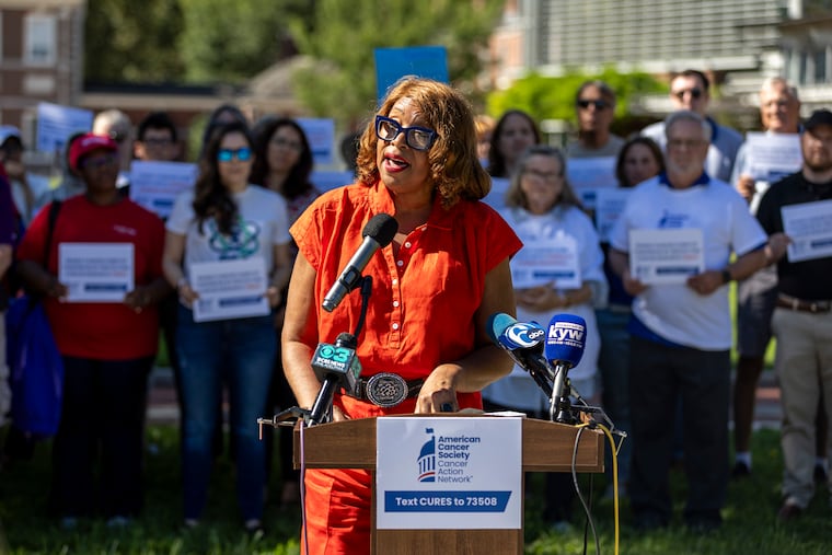 Lynne Alston, of Glenside, Pa., who is 11 years cancer-free, speaks out against federal research funding cuts at a news conference outside Independence Hall in Philadelphia on Tuesday. The co-chair of a community advisory board at Fox Chase Cancer Center, Alston participated in a clinical trial that saved her life.