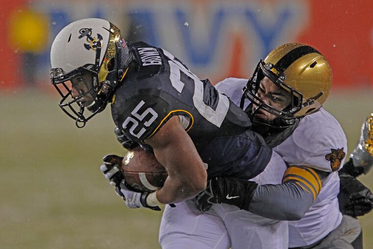 Navy's Demond Brown tries to elude Army’s John Szott. (Michael Bryant/Staff Photographer)