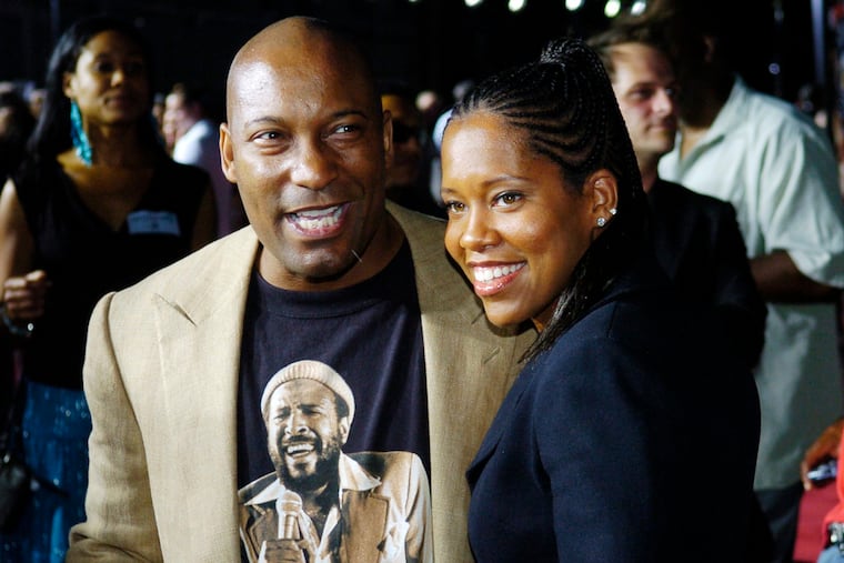 FILE - This July 20, 2005, file photo shows John Singleton, a producer for the film "Hustle & Flow," with actress Regina King at the premiere of the film in Los Angeles. Oscar-nominated filmmaker John Singleton has died at 51, according to statement from his family, Monday, April 29, 2019. He died Monday after suffering a stroke almost two weeks ago.