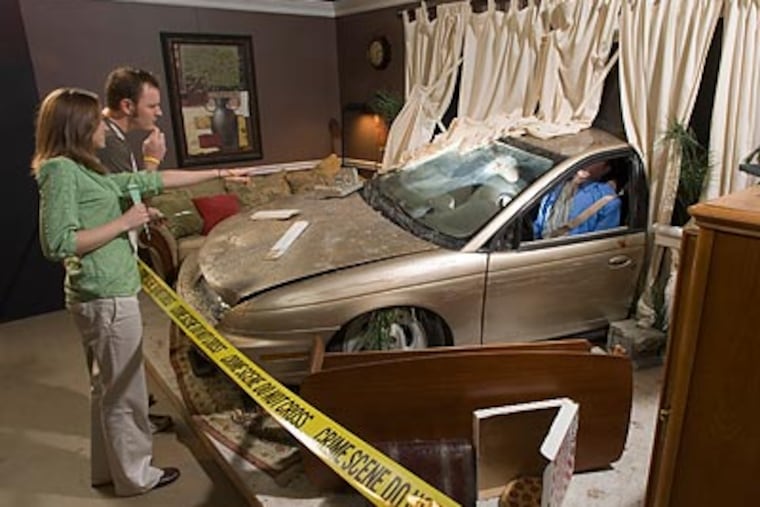 Guests look for evidence in "A House Collided" in the forensic science exhibit CSI: The Experience.