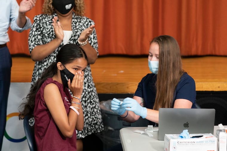 Ariel Quero, 16, left, a student at Lehman High School, reacted after getting the Pfizer COVID-19 vaccine from Katrina Taormina, right, on July 27 in New York.