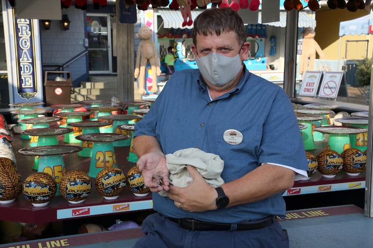 Joseph Cleary, vice president and treasurer at Morey's Piers and Water Parks in Wildwood, N.J., opens a sack of quarters at the start of the quarter coin toss game.