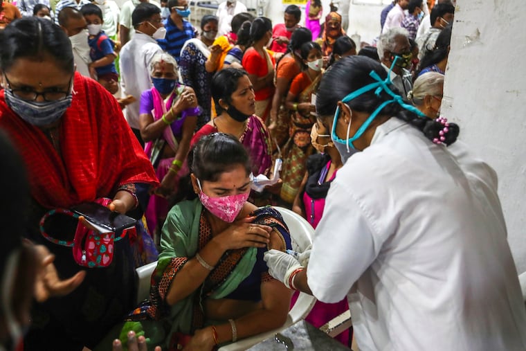 A health worker administers a dose of Covaxin as hundreds line up to receive their second dose of vaccine against the coronavirus at the municipal stadium in Hyderabad, India, Thursday, July 29, 2021.