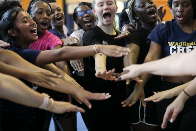 The George Washington High School cheerleading team huddles after a practice inside their school gym. Readers moved by an Inquirer story about the team's plight - they are relatively new to competitive cheer and earned a berth to compete at nationals - donated more than $30,000 to assure the team can get to Dallas for their competition.