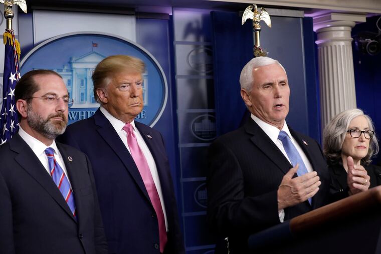 Vice President Mike Pence peaks during a news conference with President Donald Trump and members of the Coronavirus Task Force at the White House in Washington D.C., on Wednesday, Feb. 26, 2020.