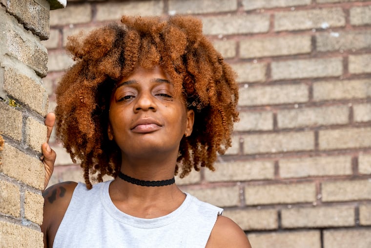 Floew Wright poses outside her West Oak Lane home July 28, 2022. She recently quit her job as a bartender after 10 years in the service industry, partially due to pay and treatment. Pennsylvania's minimum wage and tipping regulations change on Friday, Aug. 5.
