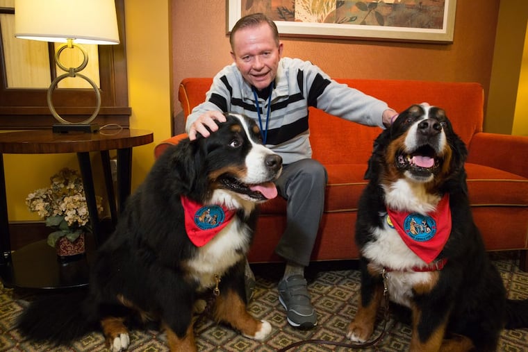 Bill Lyon makes nice with comfort dogs Harvey (left) and Darla.