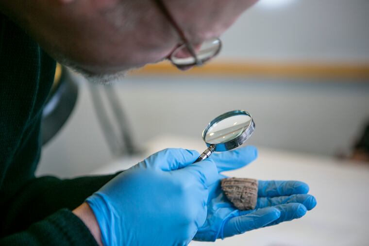 Penn researcher, William Hafford, looks at one of about 400 fragments of Sumarian tablets Penn Museum is returning to Iraq on Wednesday. The tablets were excavated in the 1920s.