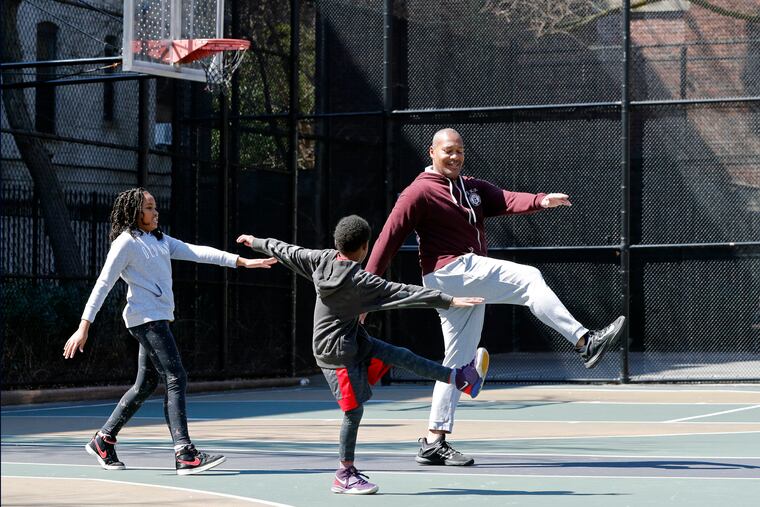 Fred Frazerk (right) does leg lifts with his son Grant, 7, and daughter Olivia, 10, on closed basketball courts in the Brooklyn borough of New York.
