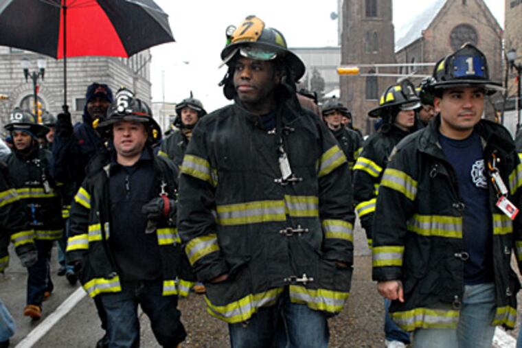 Laid-off Camden firefighters march up Federal Street to turn
in their gear at headquarters. They include Pete Perez (from left), Asante Wilson; and Carlos Colon. Police and other city workers also lost their jobs. (April Saul/Staff Photographer)