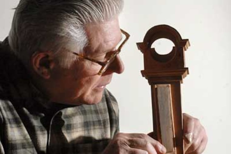 John Lawrence works on the assembly of miniature Roxbury Tall Case Clock, which can be used as a pocket watch holder. (Jonathan Wilson / Staff Photographer)