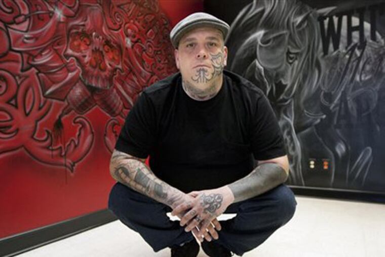 ADVANCE FOR SUNDAY JAN. 6 - In this photo, Dec. 21, 2012 photo, Bryon Burdick, co-owner of Darkside Tattoos poses in Grand Forks, N.D. Fifty years ago, most people with tattoos were ex-servicemen, bikers, circus folk or convicts, and some tattoos were the result of a drunken night of shore leave. Today, Americans spend $1.65 billion a year on tattoos, according to Statisticbrain.com. (AP Photo/The Grand Forks Herald, John Stennes)
