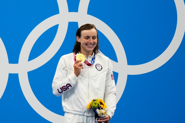 Katie Ledecky poses with her gold medal after winning the women's 800-meter freestyle final.