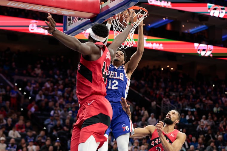 Sixers forward Tobias Harris dunks the basketball against Toronto Raptors forward Pascal Siakam (left) and center Khem Birch in the second quarter on Sunday, March 20, 2022 in Philadelphia.