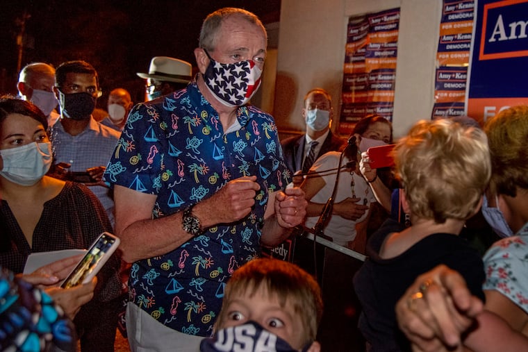 New Jersey Gov. Phil Murphy wears an American flag face mask as he mingles with the crowd outdoors at the victory party for Democratic congressional candidate Amy Kennedy on primary election day in Northfield July 7, 2020. On Wednesday the governor mandated masks be worn outdoors in settings where social distancing isn’t possible.