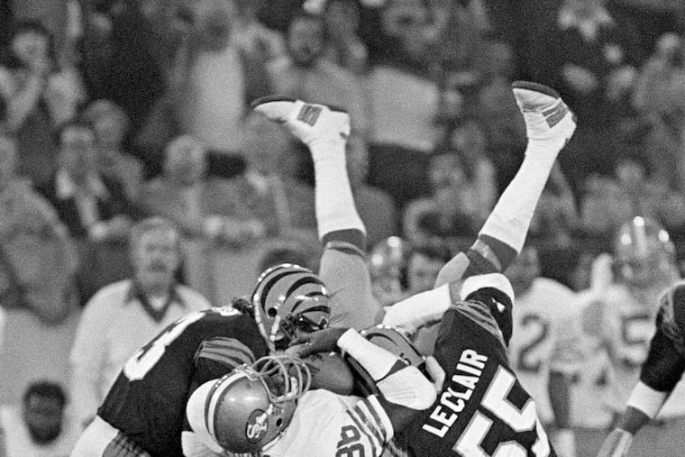 Charle Young (86) holds on to a Joe Montana pass as he is tackled by Cincinnati Bengals Jim LeClair and Bo Harris in the first quarter of Super Bowl XVI.