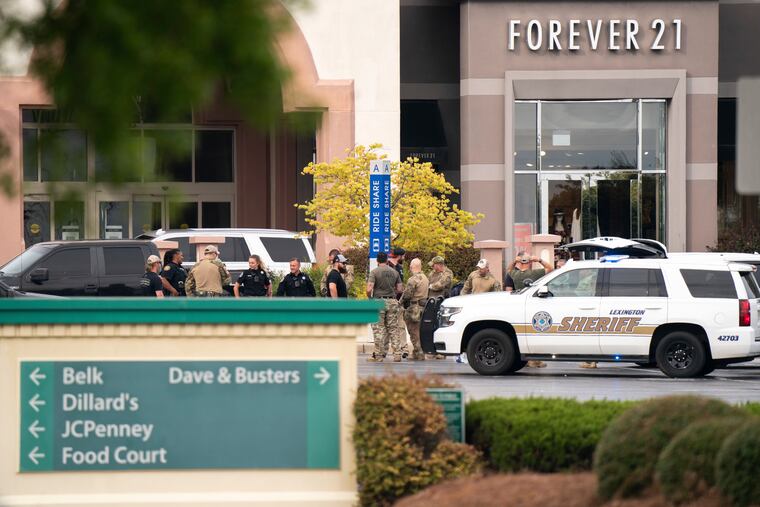 Members of law enforcement gather outside Columbiana Centre mall in Columbia, S.C., following a shooting, April 16, 2022. Authorities in South Carolina say they are investigating shooting at a club in Hampton County early Sunday, April 17, 2022 that left at least nine people injured. It was the second mass shooting in the state in as many days.
