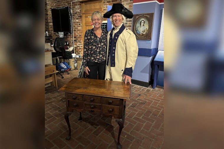 Lisa Acker Moulder, director of the Betsy Ross House, and Eric Conrad, Betsy Ross's great-great-great-great grandson, stand beside what is believed to be Betsy Ross' original sewing table.