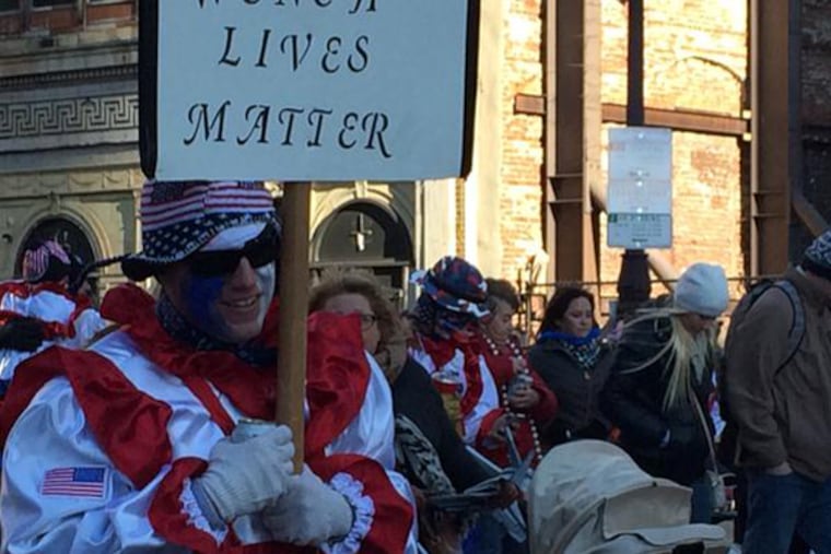 An unidentified member of a Comic Wenches group carried a sign that drew some ire on social media, Thursday, Jan. 1, 2015. (DAVID GAMBACORTA/STAFF)