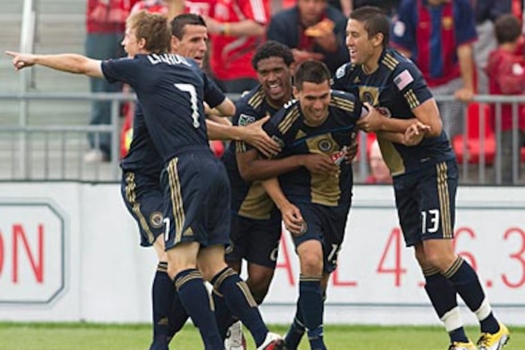 Gabriel Farfan (center) celebrates with his teammates after scoring in the second minute. (AP Photo/The Canadian Press, Chris Young)