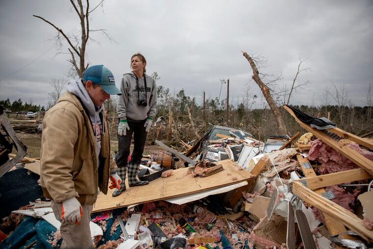 Ashley Griggs, right, helps Joey Roush, left sift through what's left of his mother's home after it was destroyed by a tornado in Beauregard, Ala., Monday, March 4, 2019. (AP Photo/David Goldman)