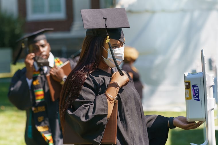 Candice Wilson, front center, uses hand sanitizer after receiving her diploma during a graduation ceremony at Rowan University, Glassboro campus, on July 14. The coronavirus disrupted one school year; it's working on another.