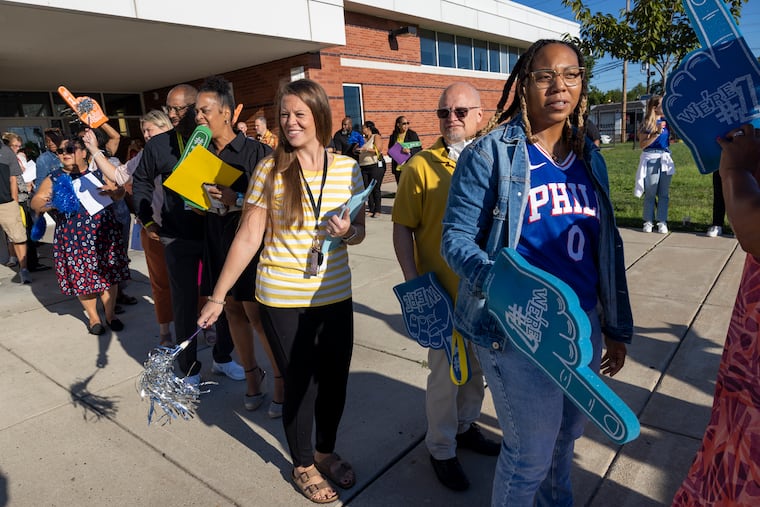 School staff wait to greet incoming students for the start of school at Morgan Village Middle School in Camden.