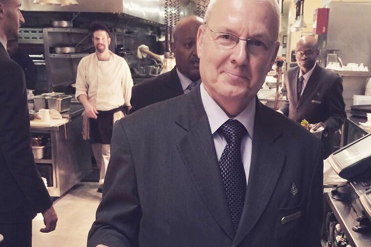 Jim Miller, a longtime Four Seasons waiter, serves the last entrée at the Fountain Restaurant before it closed Dec. 27. "I was starting to feel a little sad about it all," says Miller, who had been working at the hotel since 1983. (Four Seasons Hotel Philadelphia)