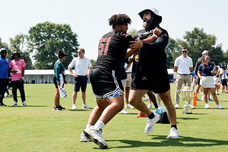 Jayce Grays, a rising senior at Glassboro High School, runs a drill with former Eagle Jason Kelce after a training camp practice Tuesday at the NovaCare Complex.
