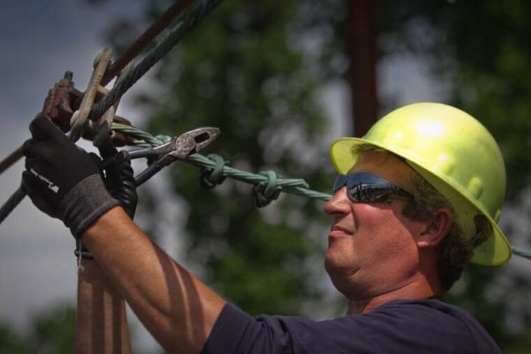 SEPTA lineman Lance Henry upgrades an overhead wire to cut train delays and improve performance. (ALEJANDRO A. ALVAREZ / Staff Photographer)