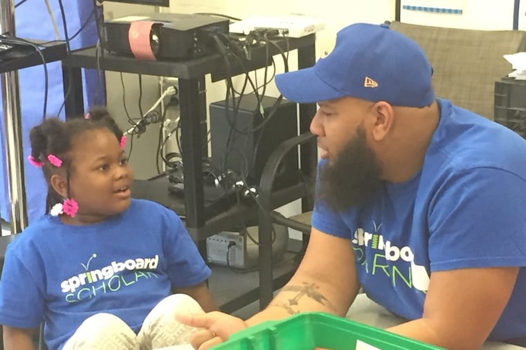 Student London Riley reads with her father during a summer reading session run by Springboard Collaborative at Independence Charter School in Philadelphia.