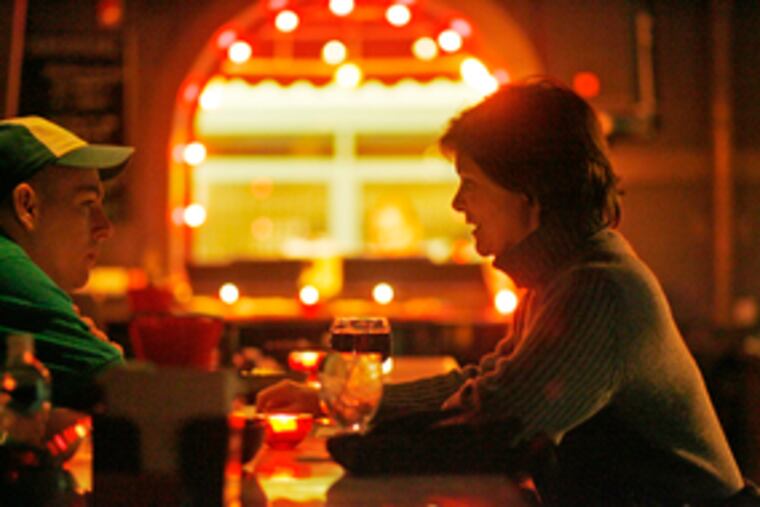 Bartender Jason Friganiak and Kathy Riordan at Cascamorto Piano Bar, popular with young professional men and women age 28 to 40; the look is way black, from shiny walls to velvet-lips love seats.