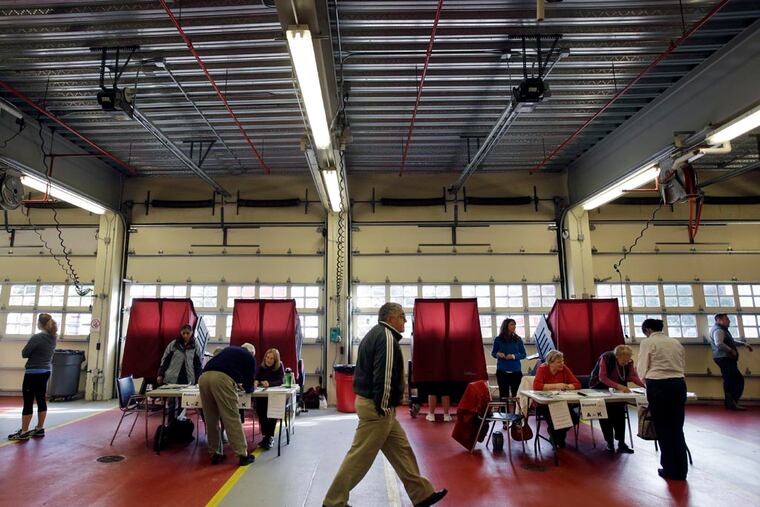 Poll workers and voters are seen in the Mendham Township, N.J., fire hall on election day, Tuesday, Nov. 5, 2013. (AP Photo/Mel Evans)