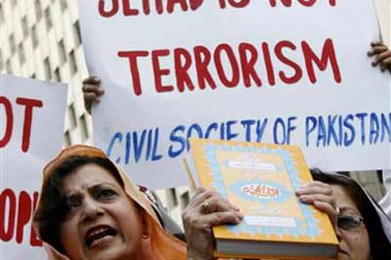 A Pakistani woman holds a copy of Muslim holy book Quran during a rally to protest the destruction of girls schools by Taliban and Islamic militants. (AP Photo/Fareed Khan)