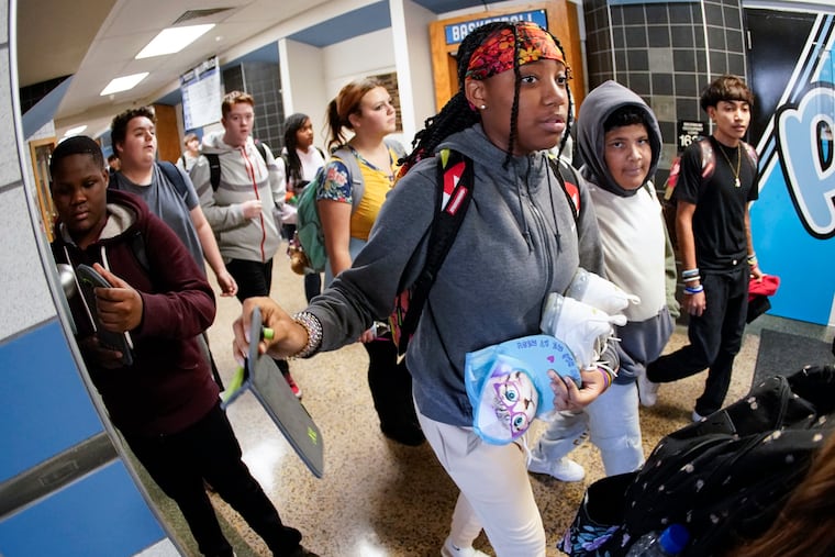 Students at Washington (Pa.) Junior High School break out their cell phones as classes end. The phones were sealed in bags during the school day. A statewide law banning cellphone use in school is needed, writes State Rep. Mandy Steele.