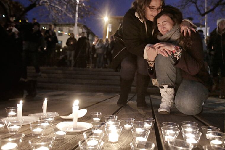 After leaving a candle at the edge of the Manayunk Canal, a woman is comforted by another during a candlelight vigil, for Shane Montgomery, at a park across from Kildare's Irish Pub at 4417 Main St. in Manayunk on Nov. 29, 2014. Montgomery, who is still unaccounted for, was last seen leaving Kildare's on Thanksgiving Eve. (Elizabeth Robertson / Staff Photographer)