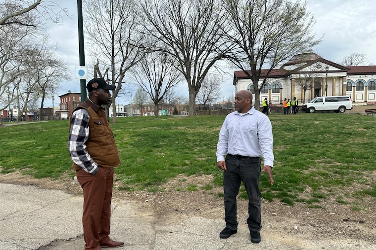 Regnarian Jenkins (left) and Tyrone Davis, staff members at the Center for Employment Opportunities Philadelphia, speak during an April 1 worksite visit at McPherson Square Park.