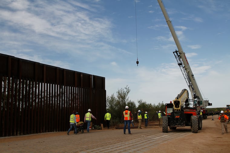 Workers break ground on new border wall construction about 20 miles west of Santa Teresa, New Mexico, Aug. 23, 2019. The wall visible on the left was built in 2018 with money allocated by Congress, while the new construction is funded by money reallocated from Department of Defense funding.