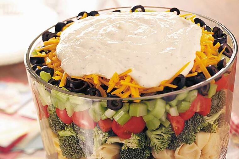 Cheese tortellini adds another dimension to this seven-layer salad topped with a Parmesan dressing.