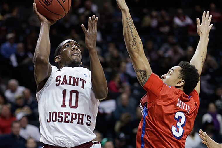 Saint Joseph's Langston Galloway, left, shoots over Dayton's Kyle Davis during the first half of an NCAA college basketball game in the quarterfinal round of the Atlantic 10 Conference tournament at the Barclays Center in New York, Friday, March 14, 2014. (AP Photo/Seth Wenig)