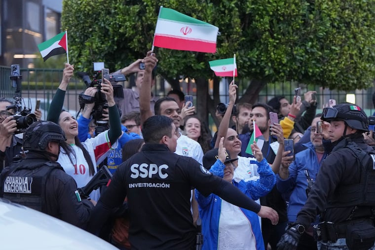 Fans for team Iran wave as players arrive at their World Cup training base in Tijuana, Mexico, on Sunday.