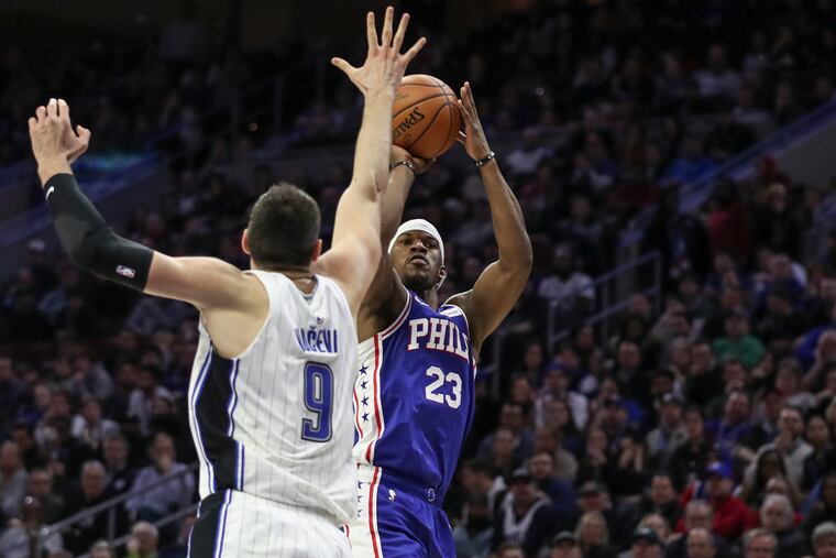 Sixers forward Jimmy Butler shoots over Orlando Magic defender Nikola Vucevic late in the fourth quarter of a game at the Wells Fargo Center in Philadelphia on Tuesday, March 5, 2019. The Sixers won the game, 114-106.
