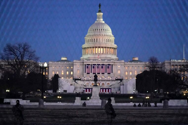 National Guard troops stand behind fencing outside the U.S. Capitol on Wednesday, Jan. 13, 2021, in Washington, D.C.