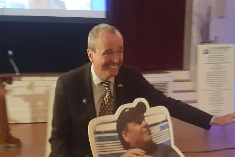 N.J. Gov-elect Phil Murphy posing with an image of Gov. Christie’s beach outing, which was taken during the 2017 state fiscal shutdown and .became a meme.