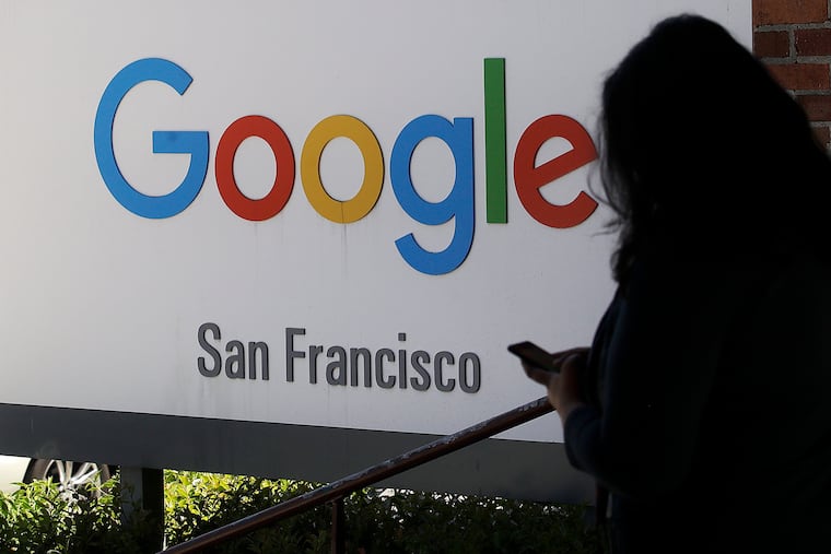 In this May 1, 2019, photo, a woman walks past a Google sign in San Francisco. Google is snooping on billions of people. (AP Photo/Jeff Chiu, File)