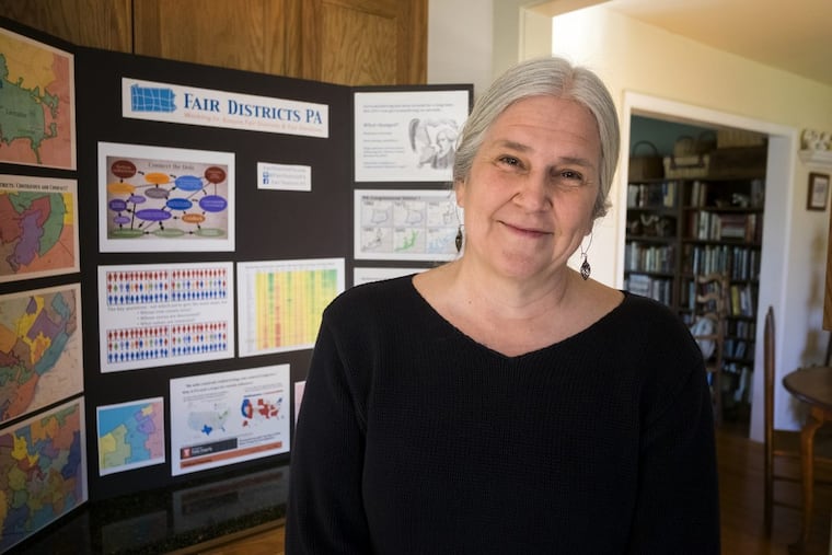 Carol Kuniholm, co-founder and chair of Fair Districts PA, stands in hereExton kitchen with a display she uses in meetings to show how voting districts have been gerrymandered.