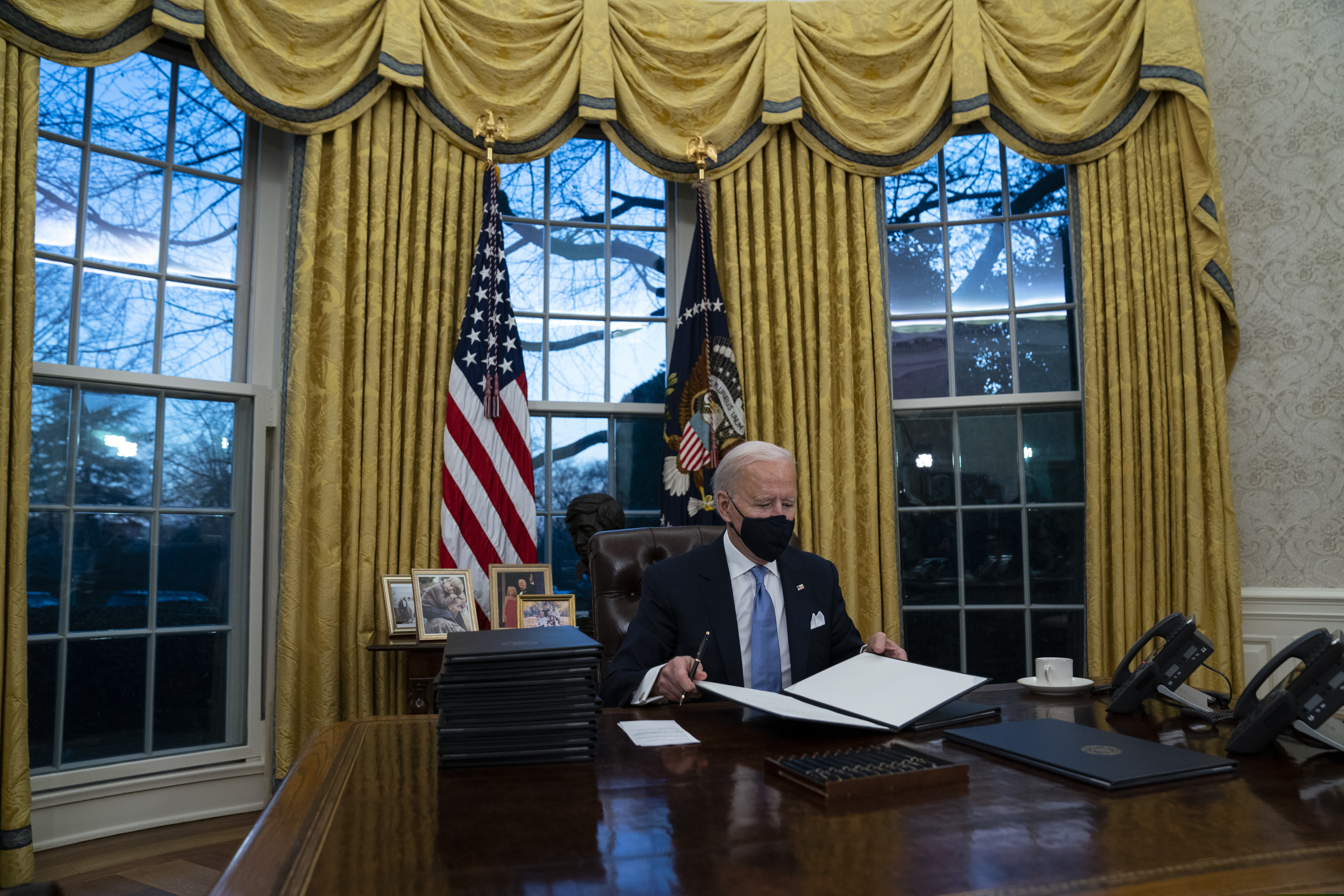 President Joe Biden signs a series of executive orders in the Oval Office of the White House in Washington.
