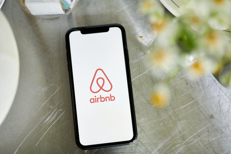 A file photo of a phone displaying the Airbnb logo.