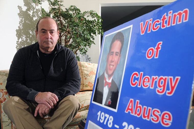 Arthur Baselice Jr., left, with a picture of his son, Arthur Baselice III on a poster about his son's death of an overdose and abuse by Rev. Charles Newman, former president of Archbishop Ryan High School in Northeast Philadelphia . ( Curt Hudson Photo )