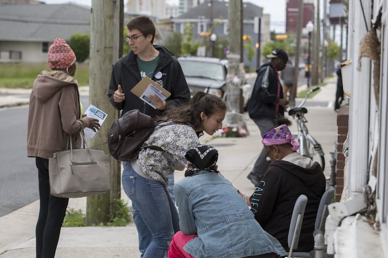 Thomas Meyer (2nd left) and Valentina Amaya (center leaning over), canvassers for Atlantic City Citizens Against the State Takeover (of the city’s water department) meet city residents on North South Carolina Avenue May 24, 2017, asking them to sign petitions to prevent Gov. Christie from privatizing the water department. CLEM MURRAY / Staff Photographer